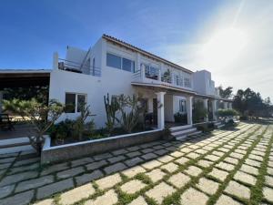 una casa blanca con un gran patio delante en Apartamentos Vista Vedrá en La Savina