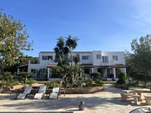 a large white building with a lot of chairs and tables at Apartamentos Vista Vedrá in La Savina