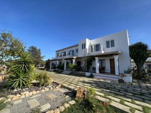 a large white house with a pathway in front of it at Apartamentos Vista Vedrá in La Savina