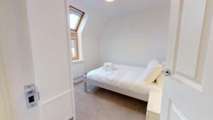 a small bedroom with a bed and a window at Carriage Crescent in Witney