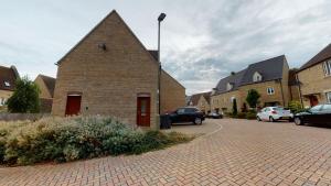 a brick building on a street with parked cars at Carriage Crescent in Witney