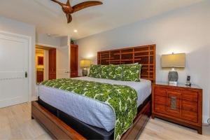 a bedroom with a large bed with a wooden headboard at MAKENA SURF, #G-101 condo in Wailea