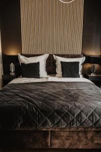 a bedroom with a large bed with black and white pillows at Boutique Hotel Cologne in Cologne