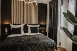 um quarto com uma cama com almofadas pretas e brancas em Boutique Hotel Cologne em Colónia