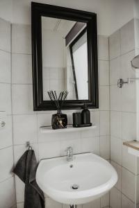 uma casa de banho com um lavatório branco e um espelho. em Boutique Hotel Cologne em Colónia