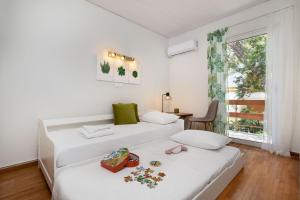 2 Betten in einem Zimmer mit Fenster in der Unterkunft Secret Aktis by BluPine in Athen