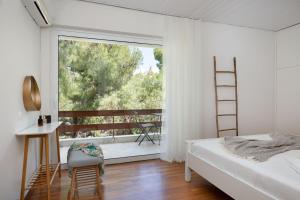 ein Schlafzimmer mit einem Bett und einem großen Fenster in der Unterkunft Secret Aktis by BluPine in Athen