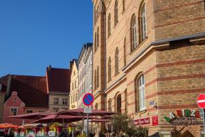 Altstadt-Studios Neuer Markt في شترالزوند: علامة الشارع أمام مبنى من الطوب