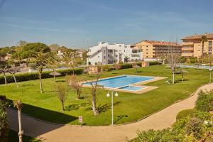a swimming pool in a park with buildings in the background at Apartamento 3H primera linea de mar y piscina GM 2 424 in Pals