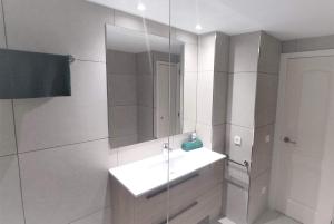 a white bathroom with a sink and a mirror at Apartamento 3H primera linea de mar y piscina GM 2 424 in Pals +56 photos