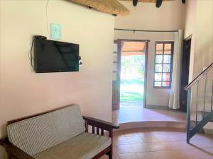 a living room with a flat screen tv on the wall at Family Lodge in Natural African Bush - 2115 in Bulawayo