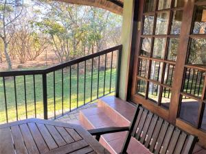 a screened in porch with a bench and a window at Family Lodge in Natural African Bush - 2115 in Bulawayo