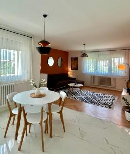 ein Wohnzimmer mit einem weißen Tisch und Stühlen in der Unterkunft Victoria Apartment Skopje in Skopje