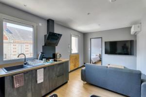 uma cozinha e sala de estar com um sofá e um lavatório em Résidence des Postes 1 em Dompierre-sur-Besbre