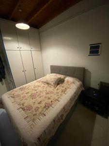a small bedroom with a bed with a floral bedspread at Oasi in Salamina