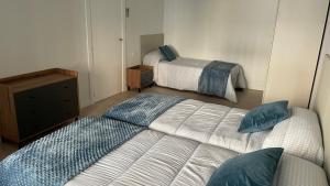 a bedroom with two beds and a dresser at Txoko Loft Moncayo in Tudela