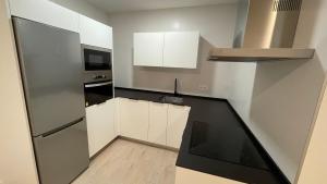 a small kitchen with white cabinets and a microwave at Txoko Loft Moncayo in Tudela
