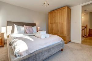 a bedroom with a large bed and a wooden cabinet at Friday Cottage in Wheatley