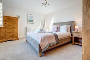 a bedroom with a bed with a wooden dresser and a drawer at Friday Cottage in Wheatley