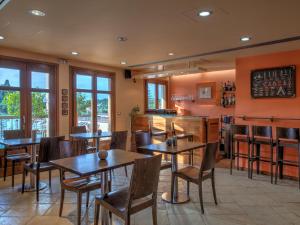 a restaurant with wooden tables and chairs and windows at Fiscardo Bay Hotel in Fiskardho