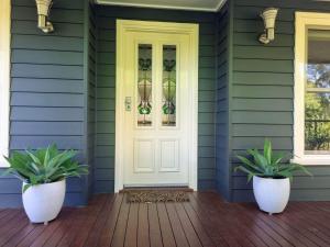 a front door of a house with two potted plants at The Birches Beechworth in Beechworth