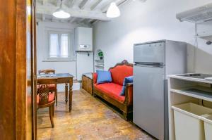 a living room with a red couch and a table at Appartamento Valbona nel cuore di Urbino in Urbino