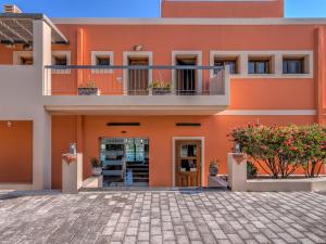 an orange building with a balcony at Fiscardo Bay Hotel in Fiskardo