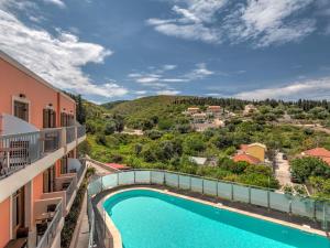 a view from the balcony of a resort with a swimming pool at Fiscardo Bay Hotel in Fiskardo