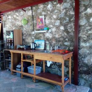 uma secretária de madeira num quarto com uma parede de pedra em Traditional stone build private studio em Verga Kalamata