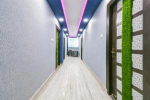 a corridor with a hallway with a purple ceiling at Flagship 79796 Hotel Royal Inn in Gulzārbāgh