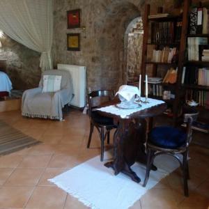 uma sala de estar com uma mesa e cadeiras e um sofá em Traditional stone build private studio em Verga Kalamata