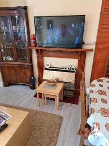 ein Wohnzimmer mit Fernseher und Tisch in der Unterkunft Luxury super double bedroom London Seven Kings Train station in Seven Kings + 7 Fotos