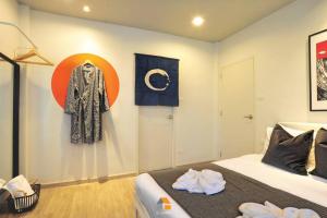 a room with a bed and a coat hanging on a wall at Arasa House by G Living -6mins MRT Klong Bang Phai in Ban Khung Taphao