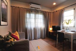 a living room with a table and a couch and a desk at Arasa House by G Living -6mins MRT Klong Bang Phai in Ban Khung Taphao