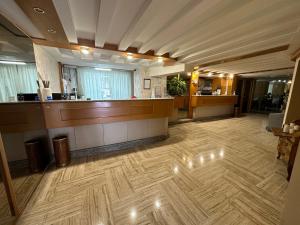 a large lobby with a reception desk and wooden floor at Hotel Città Studi in Milan