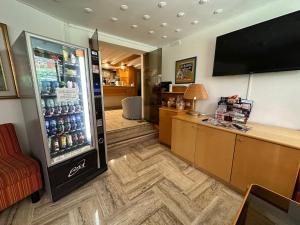 una camera con un frigorifero pieno di bottiglie di soda di Hotel Città Studi a Milano