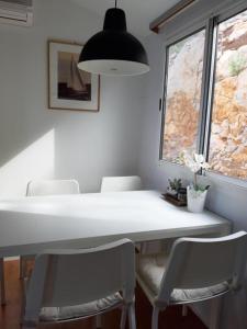 mesa de comedor con sillas blancas y ventana en Mobile Home Apartment Camp Klenovica, en Klenovica
