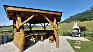 un gazebo en bois avec une table et une cloche dans l'établissement Villa Liptovská Mara, à Liptovská Anna