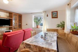 uma sala de estar com uma mesa e duas cadeiras vermelhas em Casa Valentina em Livigno