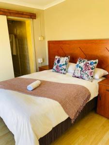 a bedroom with a large bed with two pillows at Mercy Land Guesthouse in Matatiele
