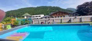 a large swimming pool in front of a resort at M4 Appartements in Wagrain