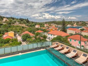a balcony with chairs and a swimming pool at Fiscardo Bay Hotel in Fiskardo