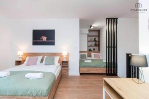 a bedroom with two beds and a table with a lamp at City Center Apartments SPA & Wellness in Gdańsk