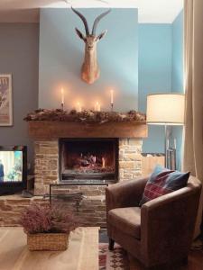 a living room with a fireplace with a chair and candles at Elegante apartamento en Escarrilla con vistas al valle in Escarrilla