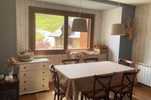 a dining room with a table and chairs and a window at Elegante apartamento en Escarrilla con vistas al valle in Escarrilla
