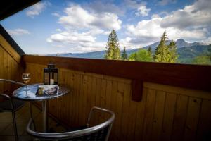 een tafel en stoelen op een balkon met uitzicht op de bergen bij Mountain Apartments Butorowy Residence in Kościelisko