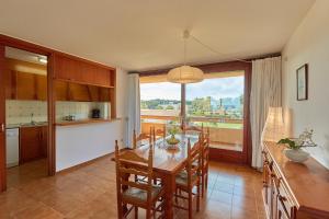 cocina y comedor con mesa y ventana grande en Apartaments Golf Mar, en Pals