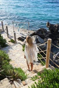 a woman walking down the steps to the beach at Paradisso Beach Villas in Amoudi