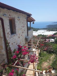 a stone house with flowers on the stairs at Istlada Taş Ev Apart - Kekova View in Antalya