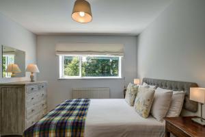 a bedroom with a bed and a window at High Trees Blenheim View in Woodstock